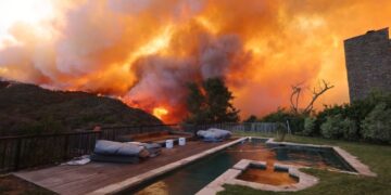 Thousands flee as Los Angeles wildfires burn out of control